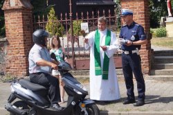 święcenie motoroweru przed kościołem, policjant rozdaje ulotki