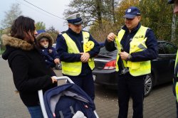 policjant daje odblask mamie z dzieckiem
