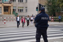 policjant dzielnicowy przy pasach w okolicach szkoły
