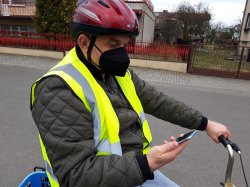 rowerzysta jedzie z telefonem komórkowym w ręku
