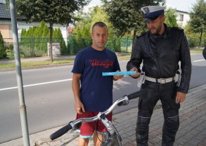 policjant daje odblask rowerzyście